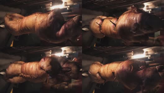 餐馆里的烤炉上用金属串烤的猪。高清在线视频素材下载