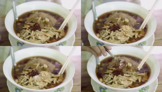 特写手用筷子夹吃泰国热面条。高清在线视频素材下载