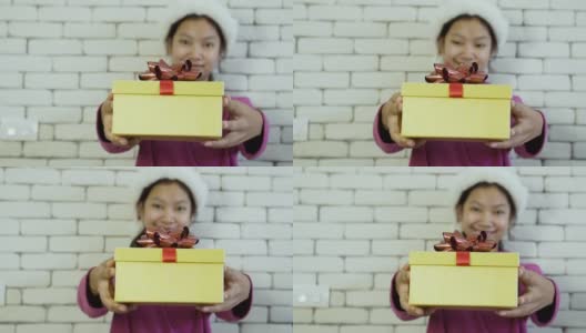 亚洲快乐女孩送礼盒在砖墙背景上。高清在线视频素材下载