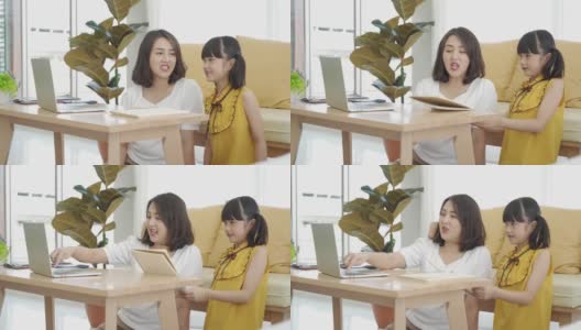 亚洲年轻妈妈用电脑笔记本教孩子在家学习或在线学习，在家在线教育的概念高清在线视频素材下载