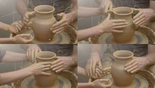 两只手交织在一起，在陶工转盘上形成一个陶罐。一个男人的手帮助一个女人的手塑造一个粘土形状。高清在线视频素材下载