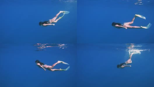女孩在清澈的蓝色海水中潜水高清在线视频素材下载