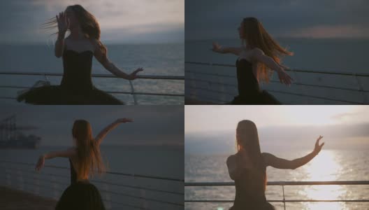 一个穿着黑色芭蕾舞裙的芭蕾舞女演员在日出或日落时在海洋或海滩的堤岸上跳着芭蕾舞。年轻美丽的金发女子与长头发练习伸展和练习。慢动作高清在线视频素材下载