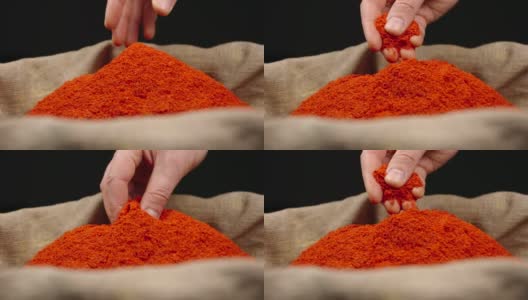 人的手从一个袋子里一堆红辣椒的顶部取下一小撮红辣椒粉高清在线视频素材下载