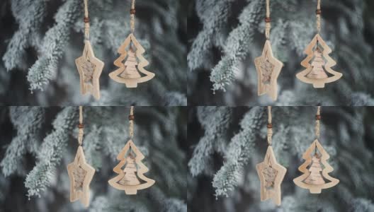 冬天公园里白雪覆盖的冷杉树枝上的木制圣诞玩具高清在线视频素材下载