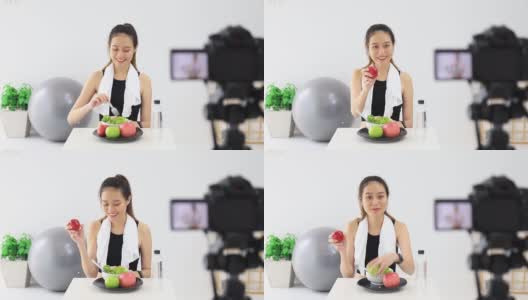 美丽的亚洲女人健康的博主展示了苹果水果和干净的减肥食品。在摄像机前录制在家的视频直播。在线社交媒体上的健身影响者。高清在线视频素材下载