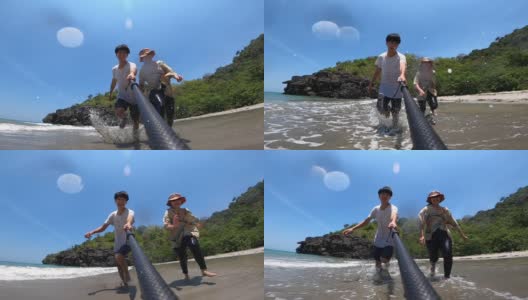 年轻夫妇在沙滩上奔跑嬉戏的慢动作高清在线视频素材下载