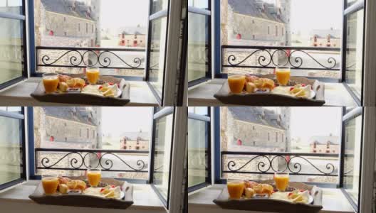 窗台上的法式早餐托盘。羊角面包，奶酪，果汁，果酱，圣女果和法棍面包高清在线视频素材下载