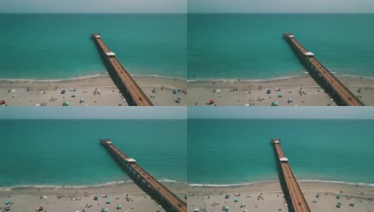 在朱诺海滩码头鸟瞰图，佛罗里达州与明亮的蓝色海水正午在春假期间在2021年3月高清在线视频素材下载