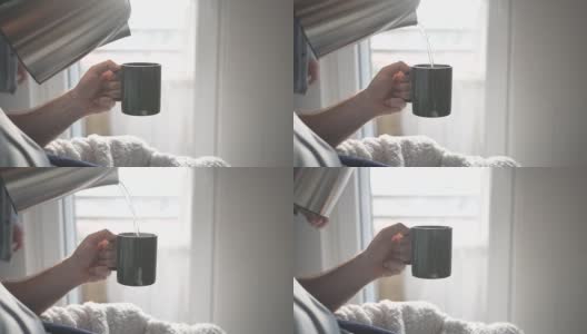 小心翼翼的男性在慢动作视频中往杯子里倒热水和茶高清在线视频素材下载