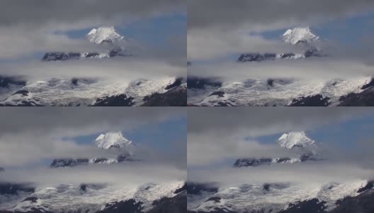 阿拉斯加冰川湾国家公园的低云之间的雪山。高清在线视频素材下载