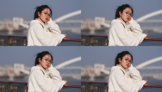 一名中国年轻女子闭着眼睛享受着来自黄浦江的微风，这是4k慢镜头。高清在线视频素材下载