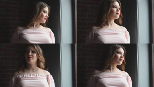 一个穿着粉红色衣服的漂亮女孩的肖像透过窗户看高清在线视频素材下载