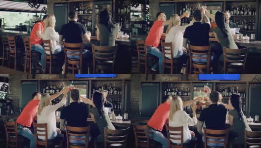 一群朋友在餐厅庆祝生日聚会，用鸡尾酒碰杯。坐在吧台的人，酒保坐在桌子的另一边，后面是箱子高清在线视频素材下载
