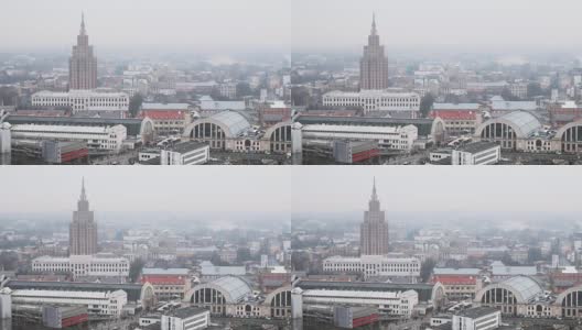 里加,拉脱维亚。顶视图城市景观在薄雾雨天。拉脱维亚科学院、里加国际长途汽车站和里加中央市场高清在线视频素材下载