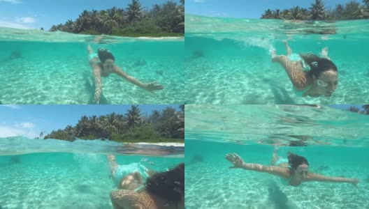 在一个完美的夏日里，快乐的年轻女子在碧绿的水中潜水高清在线视频素材下载