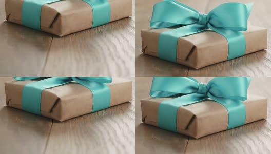 木桌上放有蓝丝带蝴蝶结的纯朴工艺纸制礼品盒高清在线视频素材下载