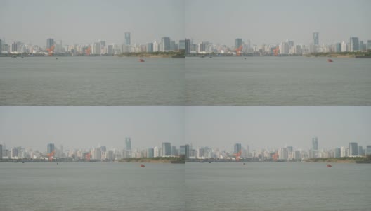 从徐汇滨江公园眺望上海外滩，蓝天背景下的摩天大楼，黄浦江上的货船，4K视频，慢镜头。高清在线视频素材下载