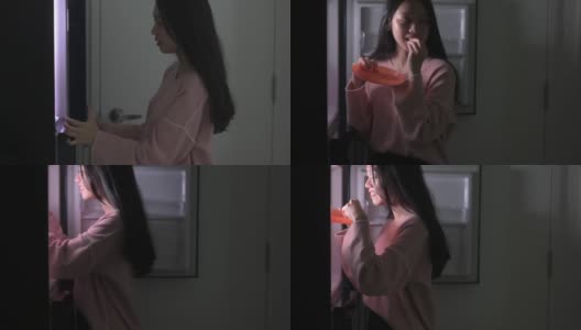 一位亚洲中国女性晚上打开冰箱吃东西高清在线视频素材下载