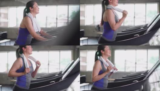 健康的年轻女子在跑步机上慢跑高清在线视频素材下载