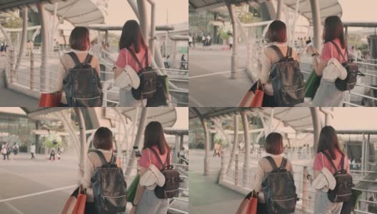 两名女游客边走边用手机，慢镜头高清在线视频素材下载