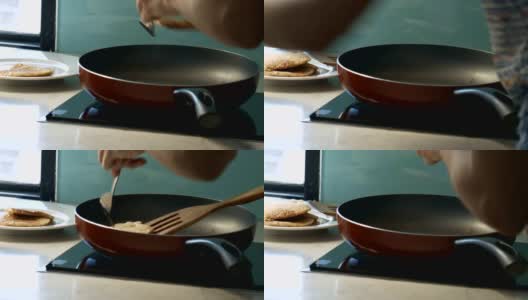 女孩把平底锅里的美味煎饼放到白盘子里高清在线视频素材下载