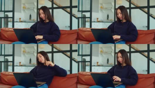 迷人的亚洲女人在家里用笔记本电脑工作高清在线视频素材下载