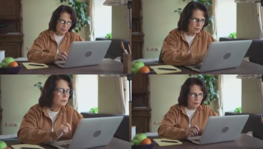 妇女工作与笔记本电脑和坐在办公桌在家庭办公室流行病期间高清在线视频素材下载