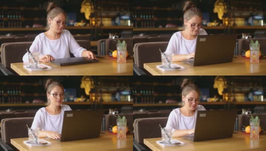 自由职业者女子打开她的笔记本电脑，面部识别系统得到面部检测扫描进入电脑。红外摄像机扫描女性的面部。在电子生物统计学。女性开始在咖啡馆工作高清在线视频素材下载
