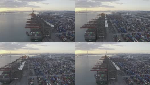 夕阳下，几艘大型货轮停在港口装卸集装箱。高清在线视频素材下载