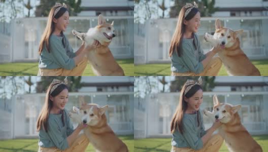 快乐在一起，有吸引力的亚洲女性年轻的成年女性喜欢与可爱的柯基狗玩，日落在室外草地后院高清在线视频素材下载