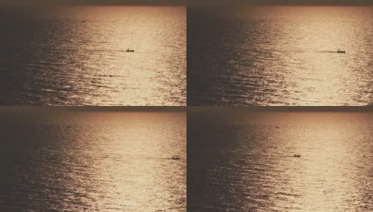 海面上的渔舟在日出或日落中发出金光的剪影高清在线视频素材下载