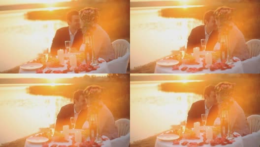 一对情侣在日落时分在海滩上吃晚餐高清在线视频素材下载