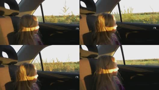 年轻的白人女孩看着车窗开车。日落夏秋黄昏。金色的夕阳。高清在线视频素材下载