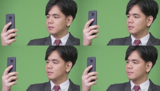 年轻英俊的亚洲商人使用手机高清在线视频素材下载