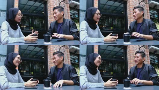 一对年轻的亚洲夫妇坐在当地的咖啡店里高清在线视频素材下载