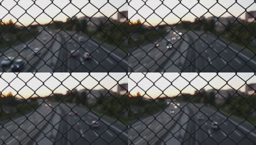 铁丝围栏后的夜间交通高清在线视频素材下载