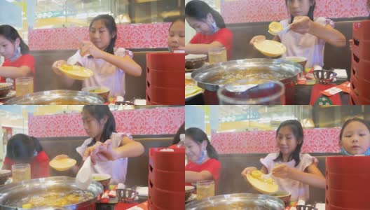 孩子们一起在餐馆吃素琪烧中国菜火锅和蔬菜。高清在线视频素材下载