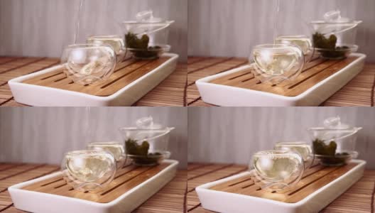 中国绿茶从玻璃茶壶到一个小杯子高清在线视频素材下载