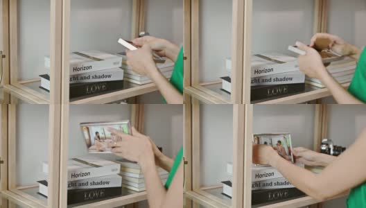 女手安排和把一对相框放在书在木架高清在线视频素材下载