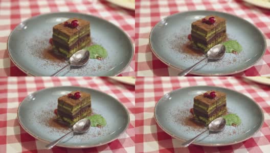 精选抹茶绿茶层蛋糕，上面点缀着可可和樱桃浆果高清在线视频素材下载