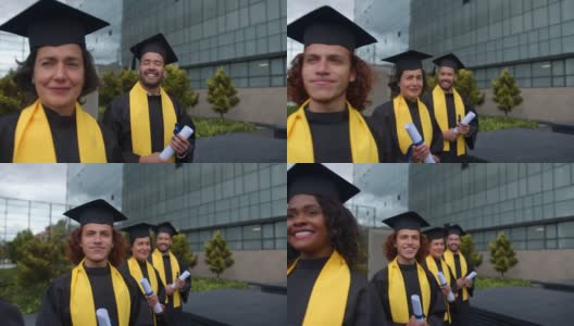 毕业典礼当天，一群多种族的研究生手拿毕业证站成一排，看上去很开心高清在线视频素材下载