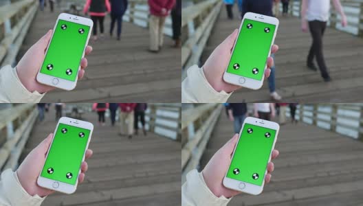 一名女子手持绿色屏幕显示智能手机在落基点公园高清在线视频素材下载