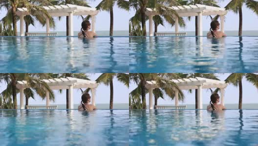 旅行电影的女人放松在热带度假无限泳池高清在线视频素材下载
