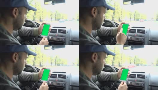 一只手拿着一个绿色空白屏幕的智能手机在车里为方向，按摩，位置，业务。男人坐在现代汽车里，用智能手机工作——绿色屏幕——特写。色度键。高清在线视频素材下载