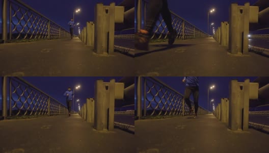 晚上在桥边慢跑的运动员。一个穿着运动服的男人在晚上跑步。男正在健身，车路过。高清在线视频素材下载