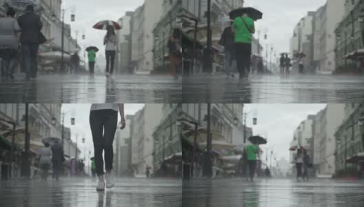 背景大雨天在城市街道。真正的时间。人们在雨中带着雨伞上下班。年轻女孩拿着五颜六色的雨伞。模糊的散景。自然背景高清在线视频素材下载