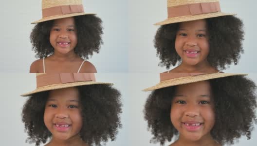 美丽可爱的非洲小女孩的肖像站着微笑，卷发发型和镜头在摄影棚。高清在线视频素材下载