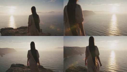 童话故事里的长发小女孩清晨走到悬崖边，欣赏美丽的海景。女孩性格会日出在高山附近的海。仙境景观视图高清在线视频素材下载