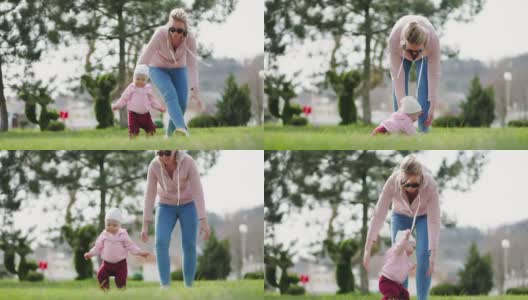 一位白人母亲教婴儿走路。母亲和孩子在公园里散步。真正的时间。缓慢的运动。儿童发展的概念高清在线视频素材下载